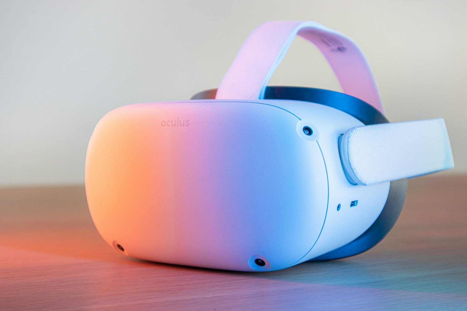 A white standalone VR headset lit in pink and blue