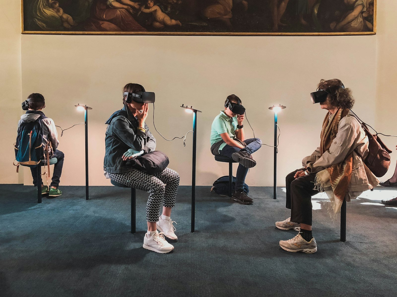 Four people seated in a row, each wearing a VR headset